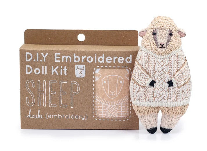 DIY embroidered doll kit for a sheep with a completed embroidered sheep toy next to it.