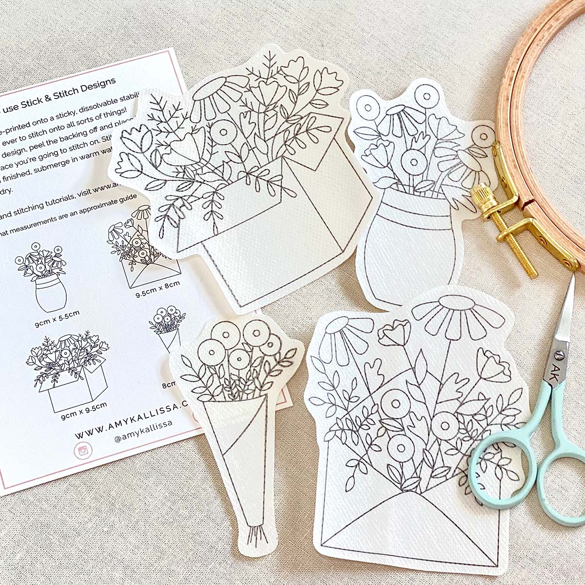 Floral embroidery patterns on paper with scissors and an embroidery hoop.