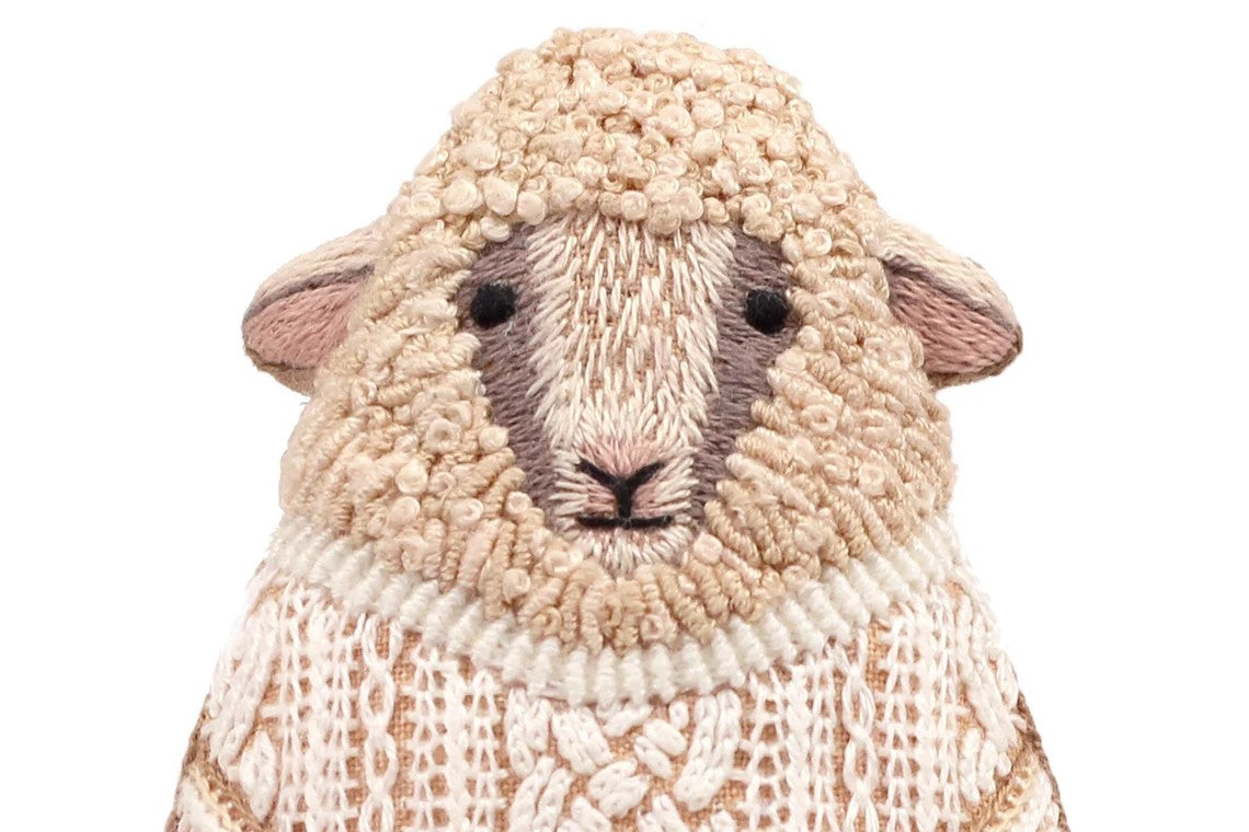Sheep-shaped object with a knitted pattern on a white background