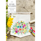 Embroidered banner with colorful floral design and text on a wooden surface.