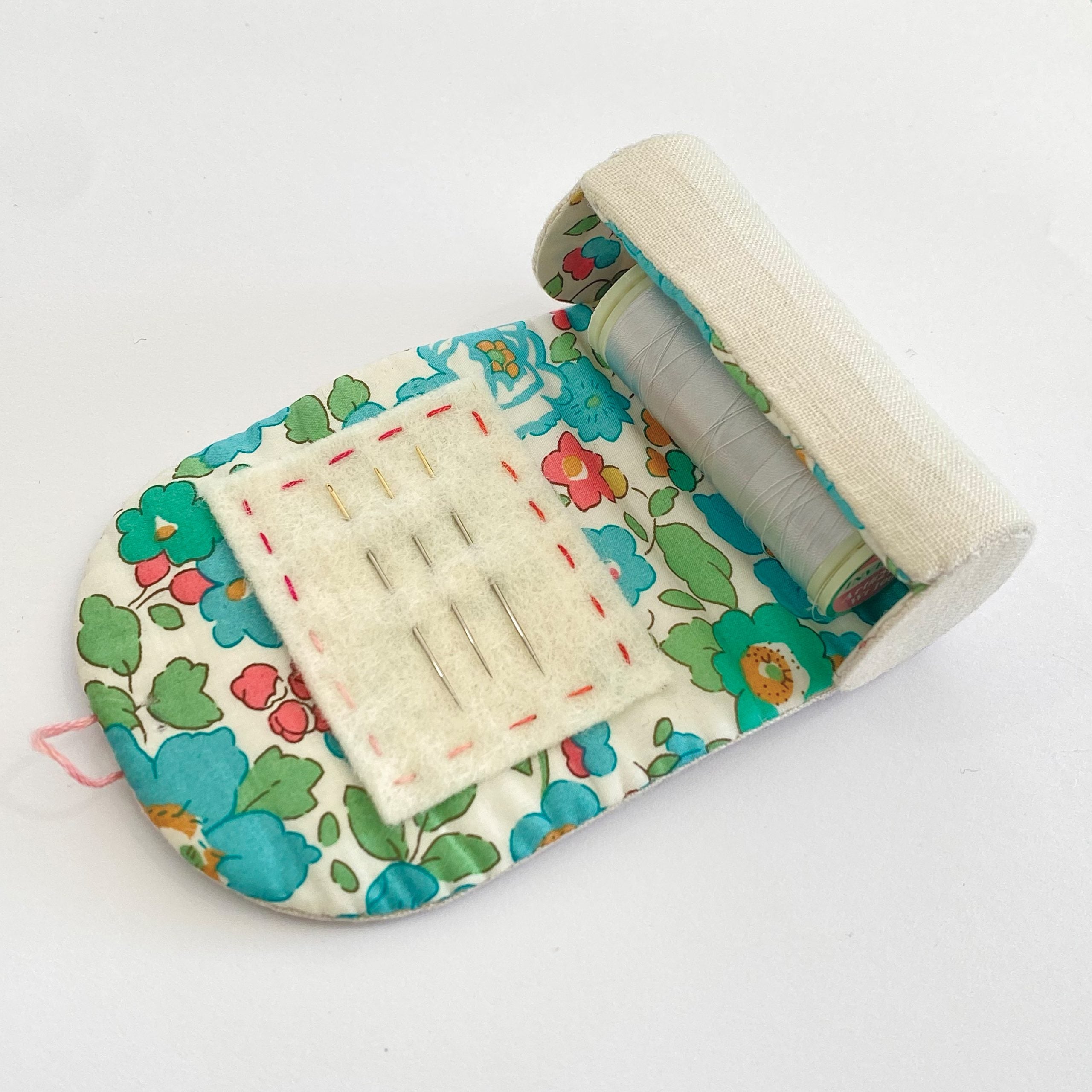 Floral-patterned sewing kit with needles on a white background