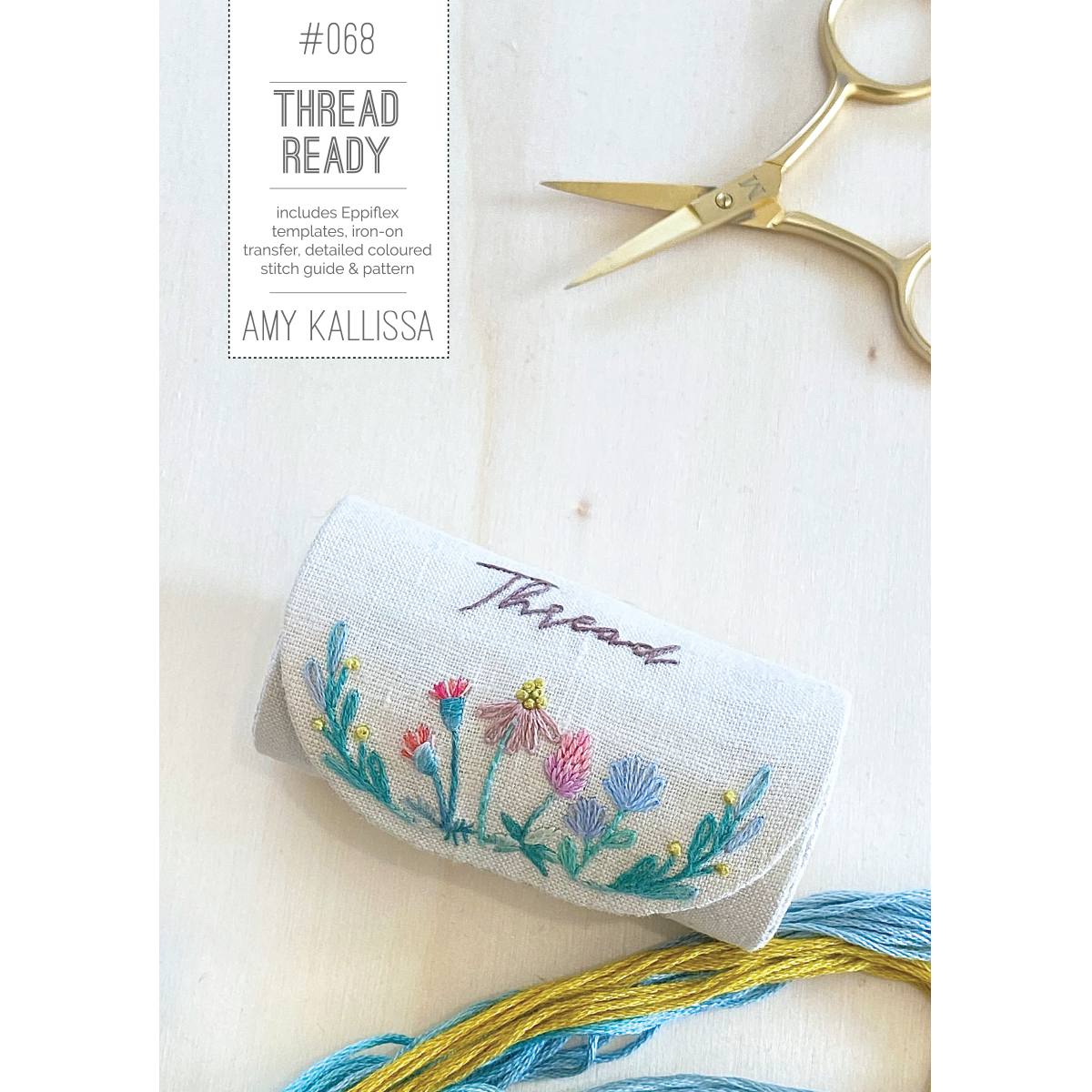 Embroidery pattern with floral design, scissors, and thread on a light background