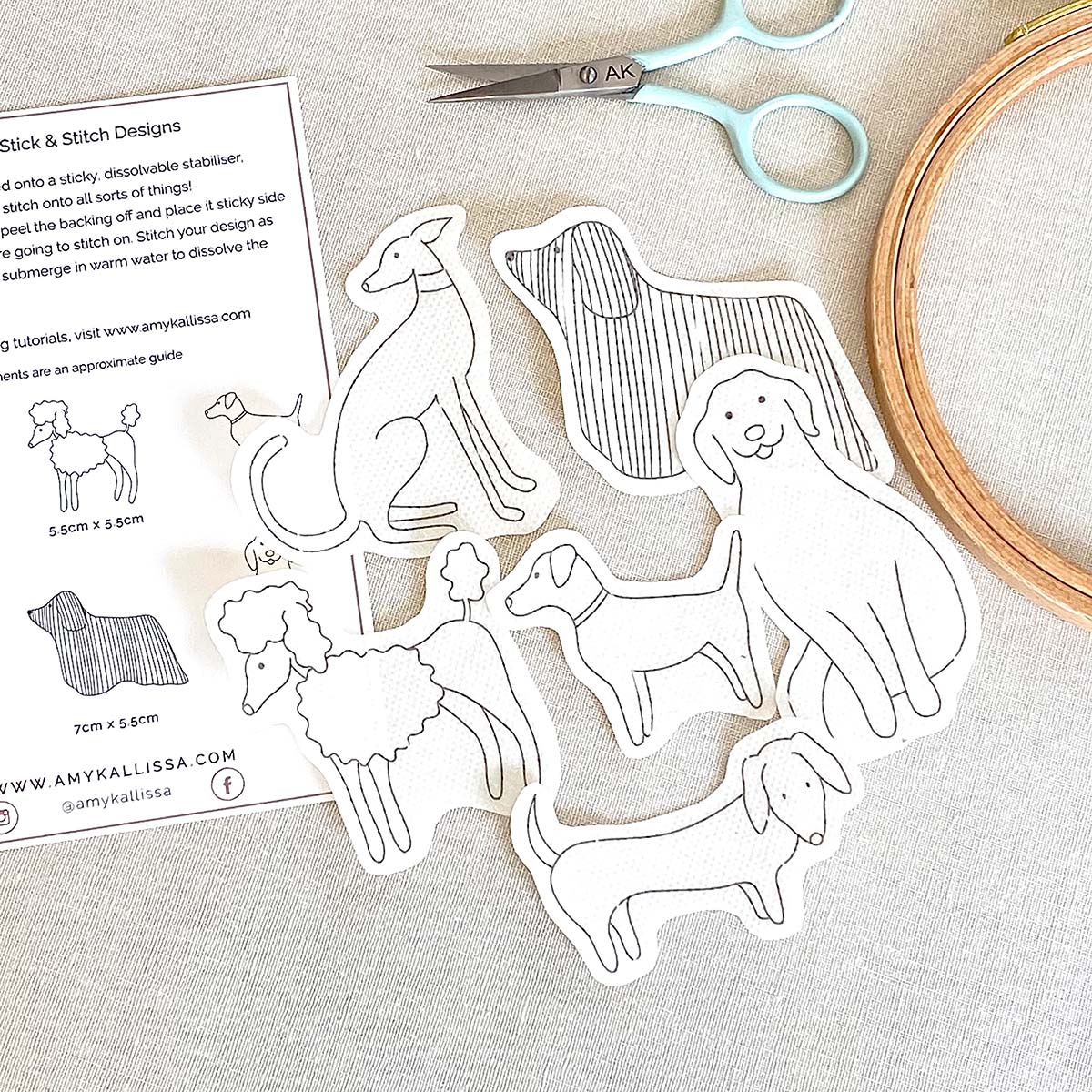 Set of dog-themed embroidery patterns with scissors and a hoop on a light background