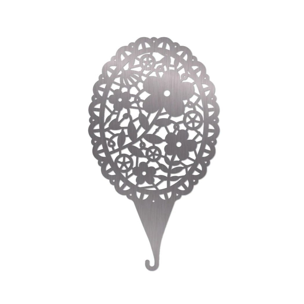Decorative metal needle treader with floral pattern on a white background